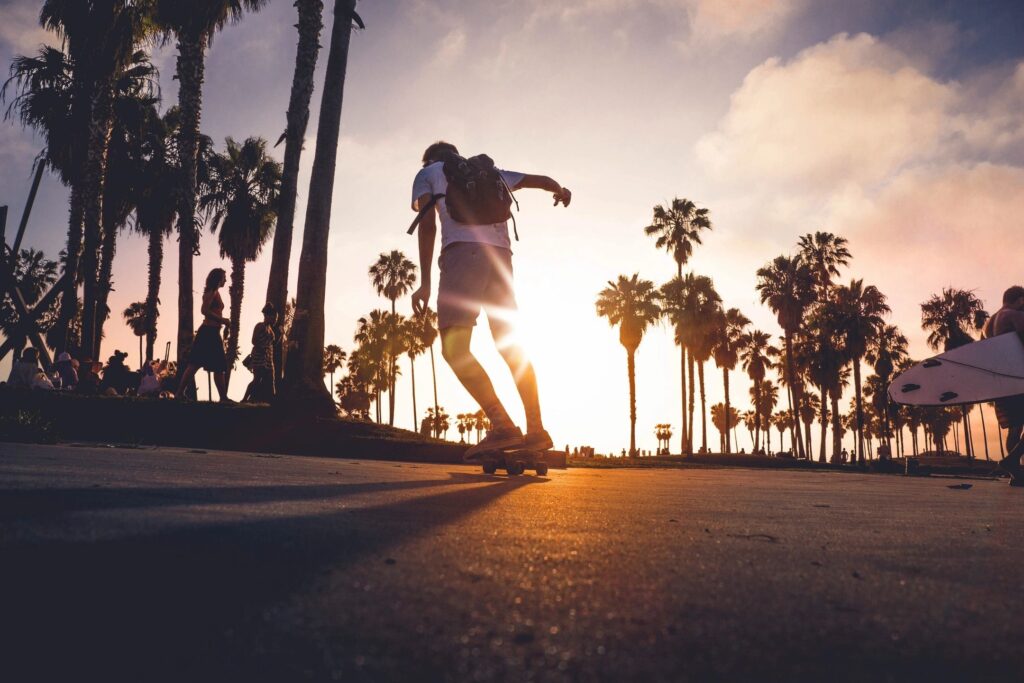 Boy rides skateboard at dusk.